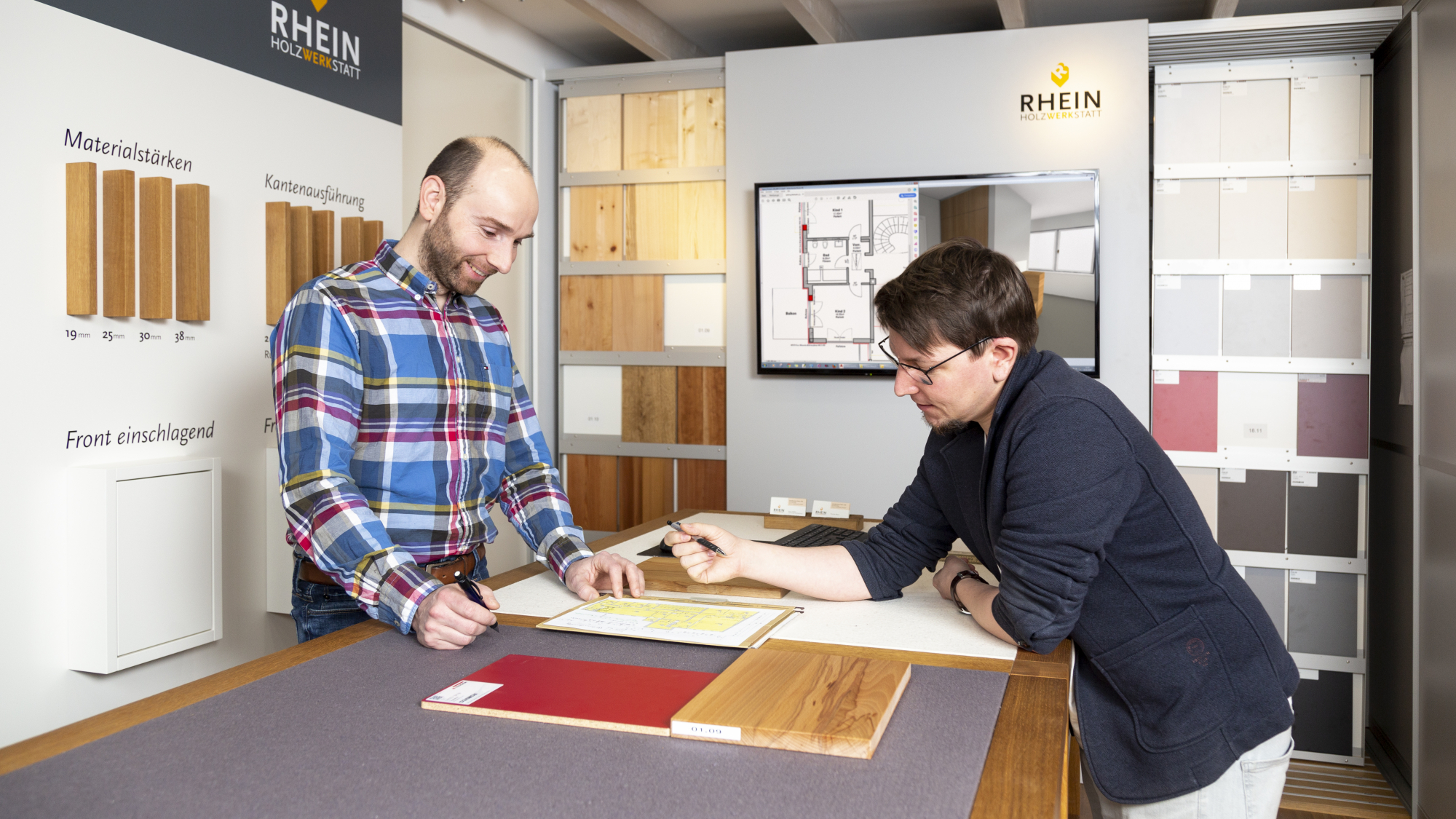 Thomas Rhein und Kevin Rauer in der Ausstellung, besprechen Kundenmuster und Zeichnungen