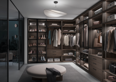 Raumplus Gleittüren - Moderner, offener Ankleideraum mit maßgefertigtem Schranksystem und eleganten Glaselementen von raumplus, im urbanen Nachtambiente.
